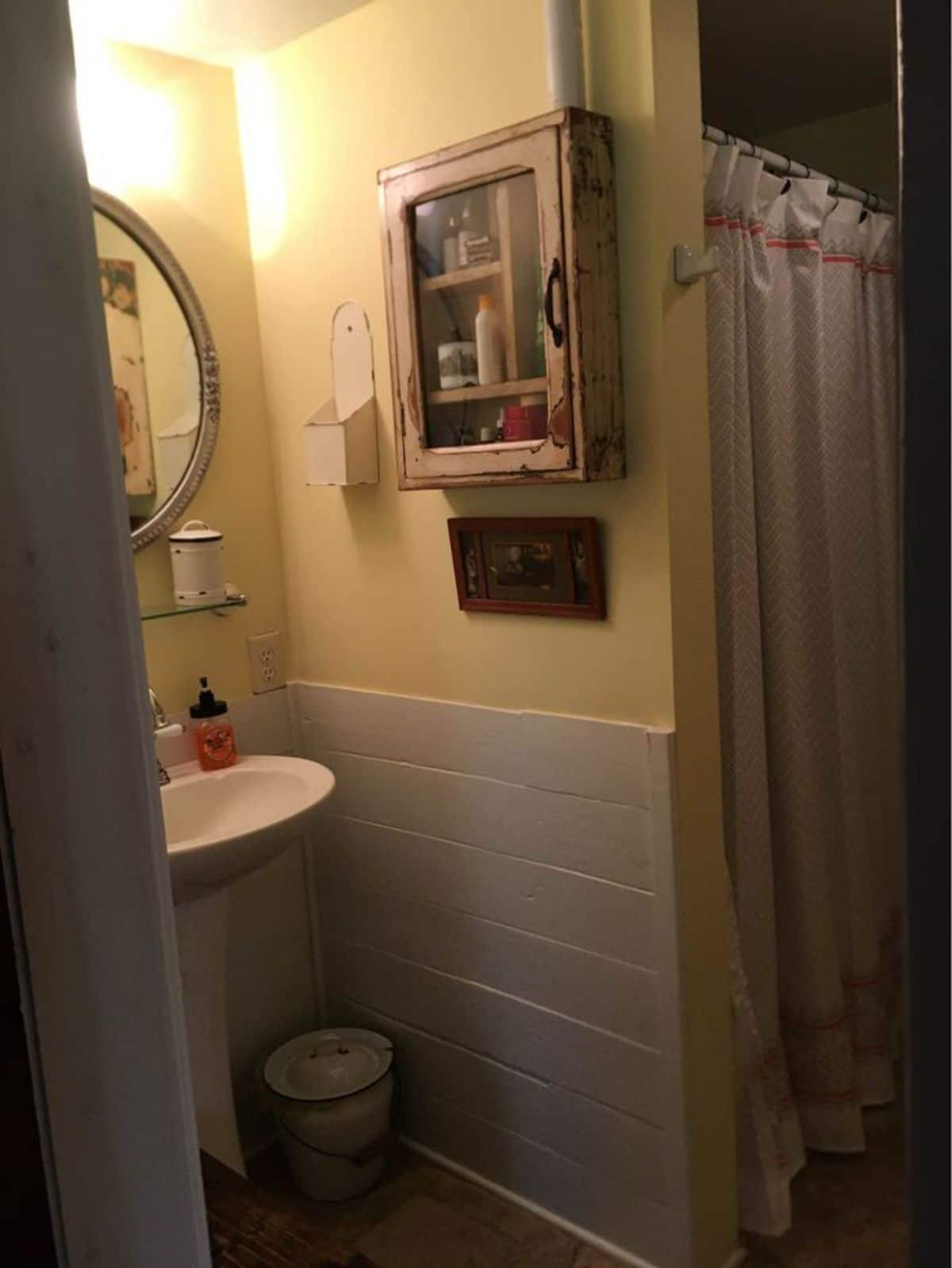 open door into bathroom with white tile and standing white sink