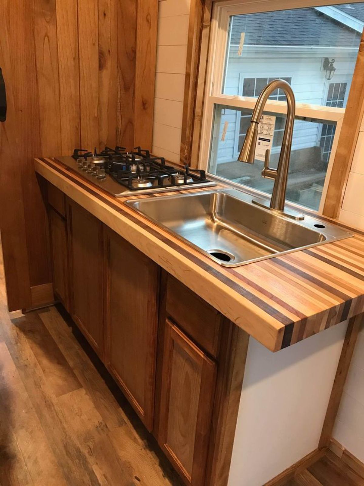 multi-colored butcher block style counters with sink and stove and wood cabinets below