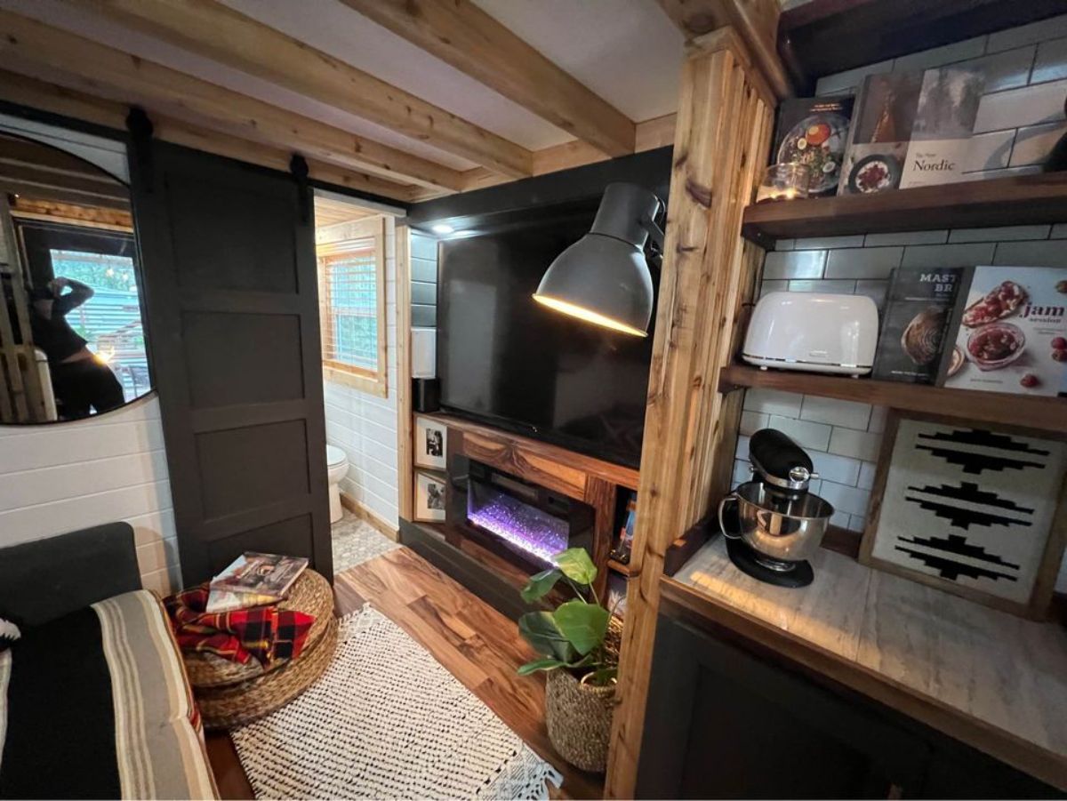 wall mounted television set and 2 seater couch at Stunning Tiny House on Wheels