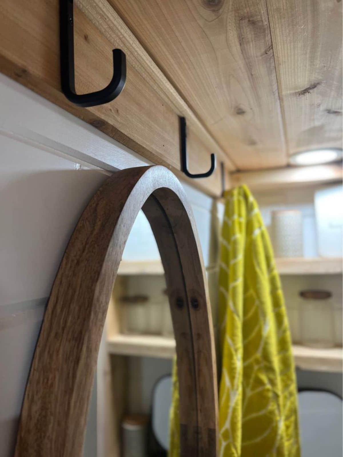 strategically fixed hooks and mirror on tiny house on wheels