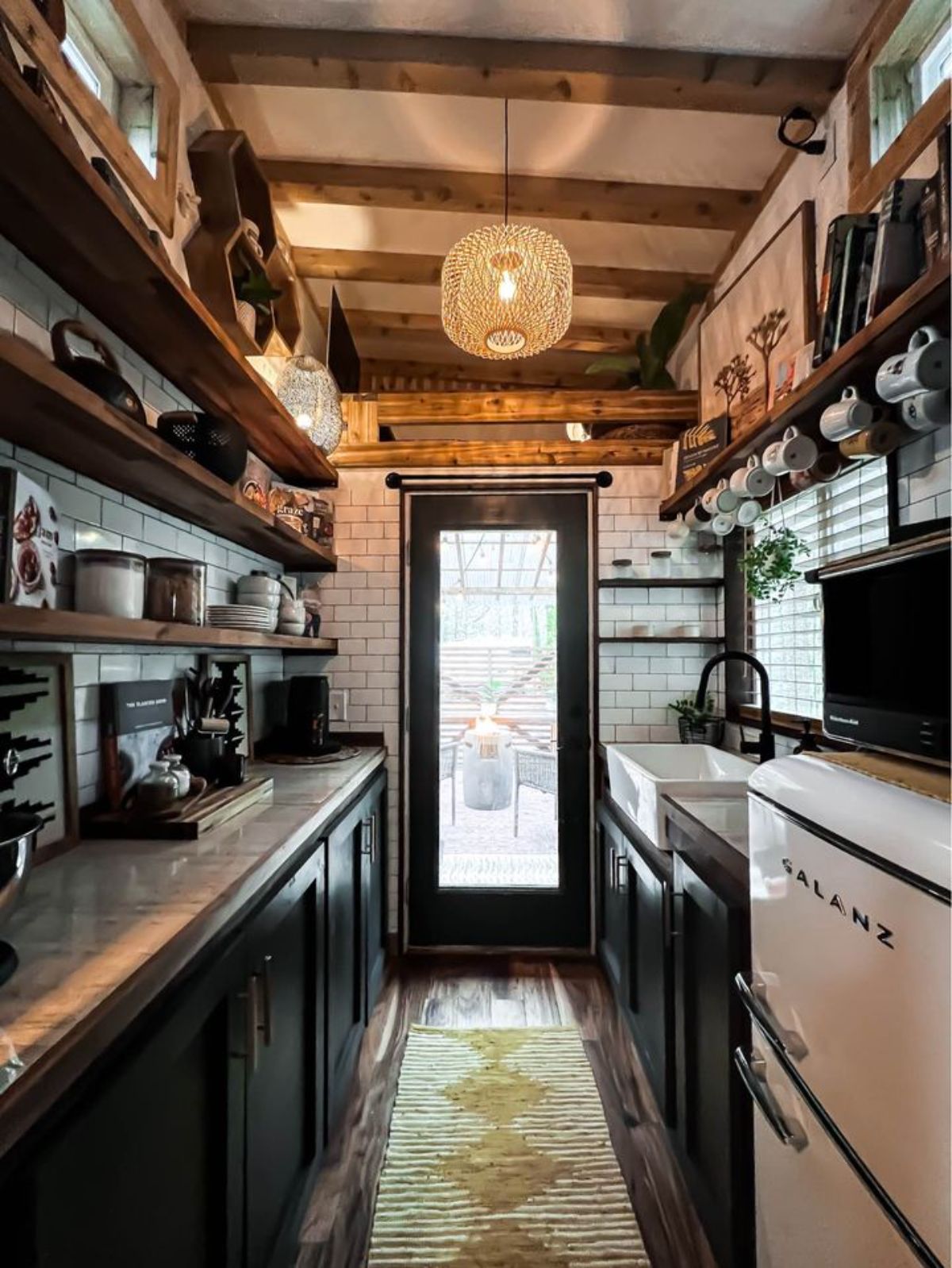Kitchen of tiny house on wheels with ample storage space and cabinets