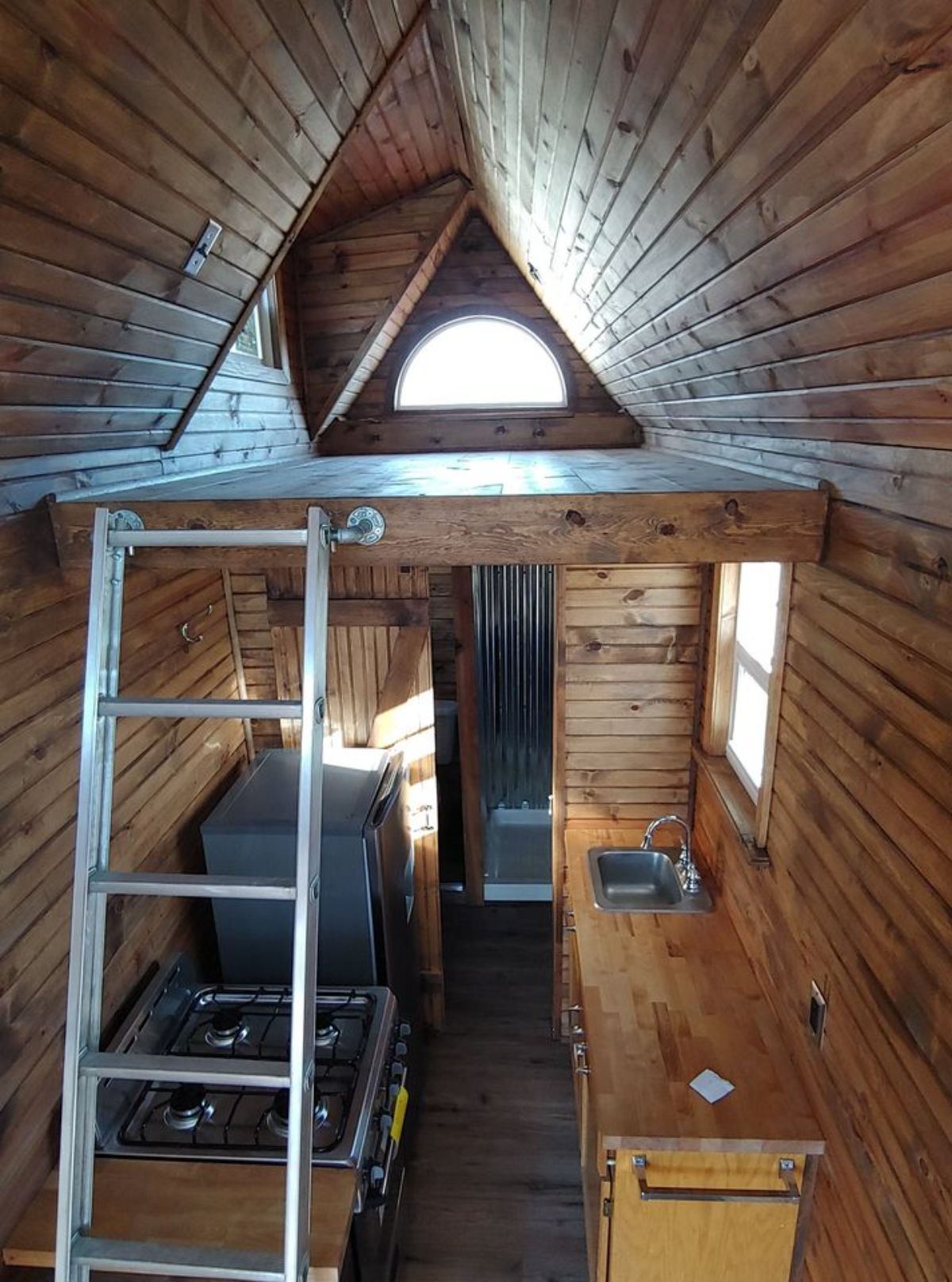 a stairway to the bedroom and kitchen of tiny home