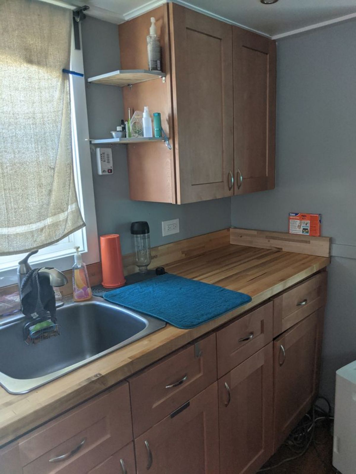 Kitchen of 196 sf Tiny House on Wheels has a sink and wooden cabinet with drawers