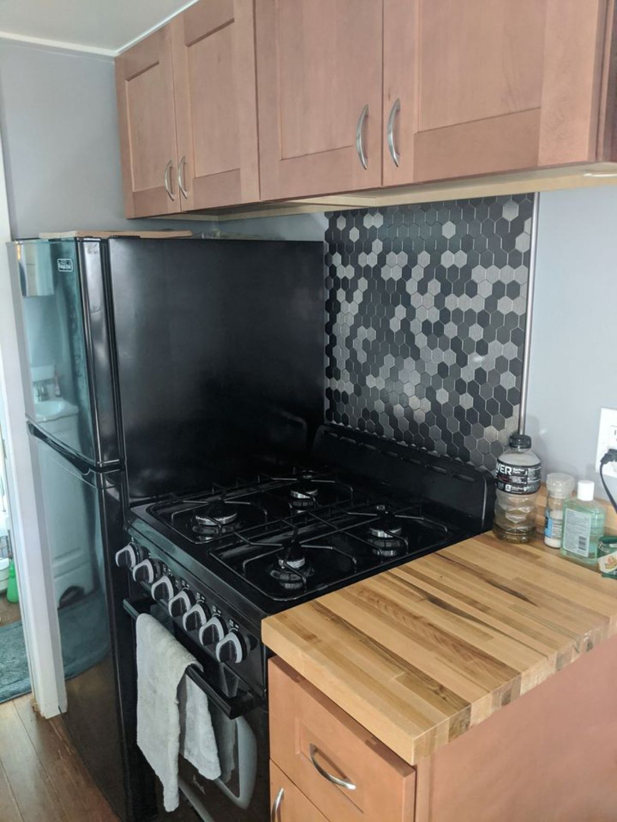 Kitchen of of 196 sf Tiny House on Wheels has propane burner cum oven