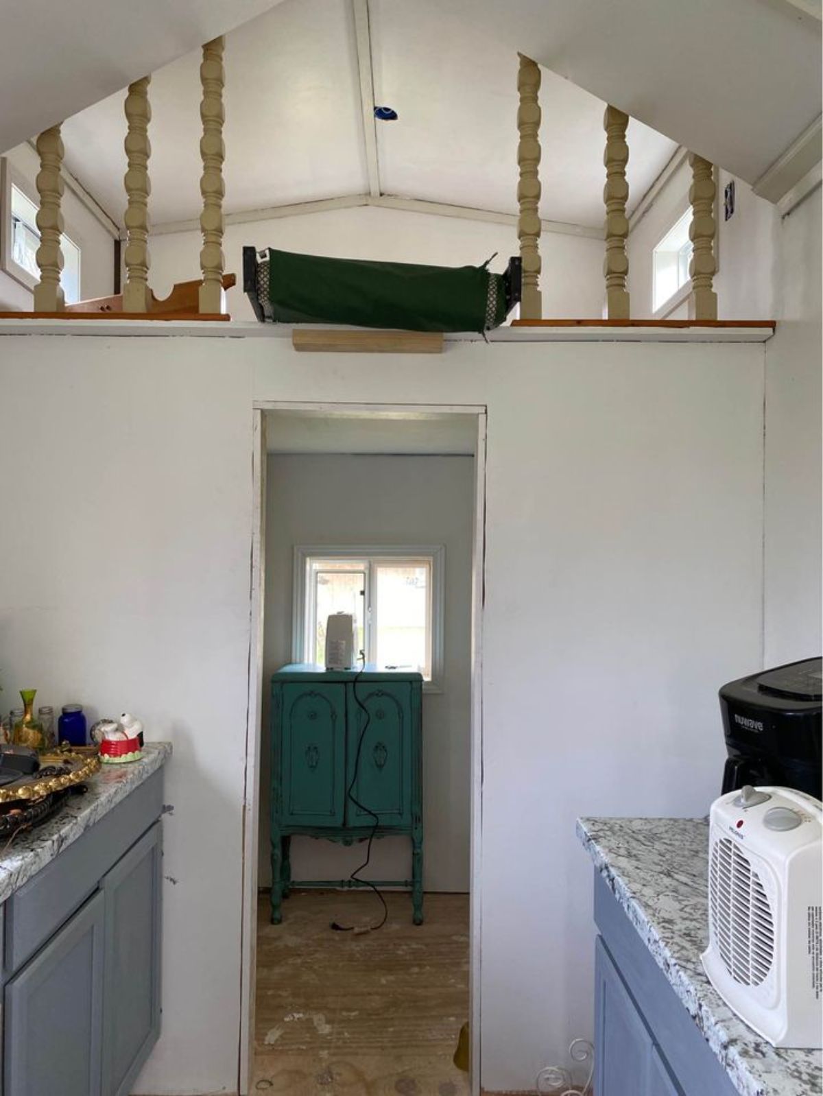 The loft of 20’ Tiny House on Trailer is accessible through ladder