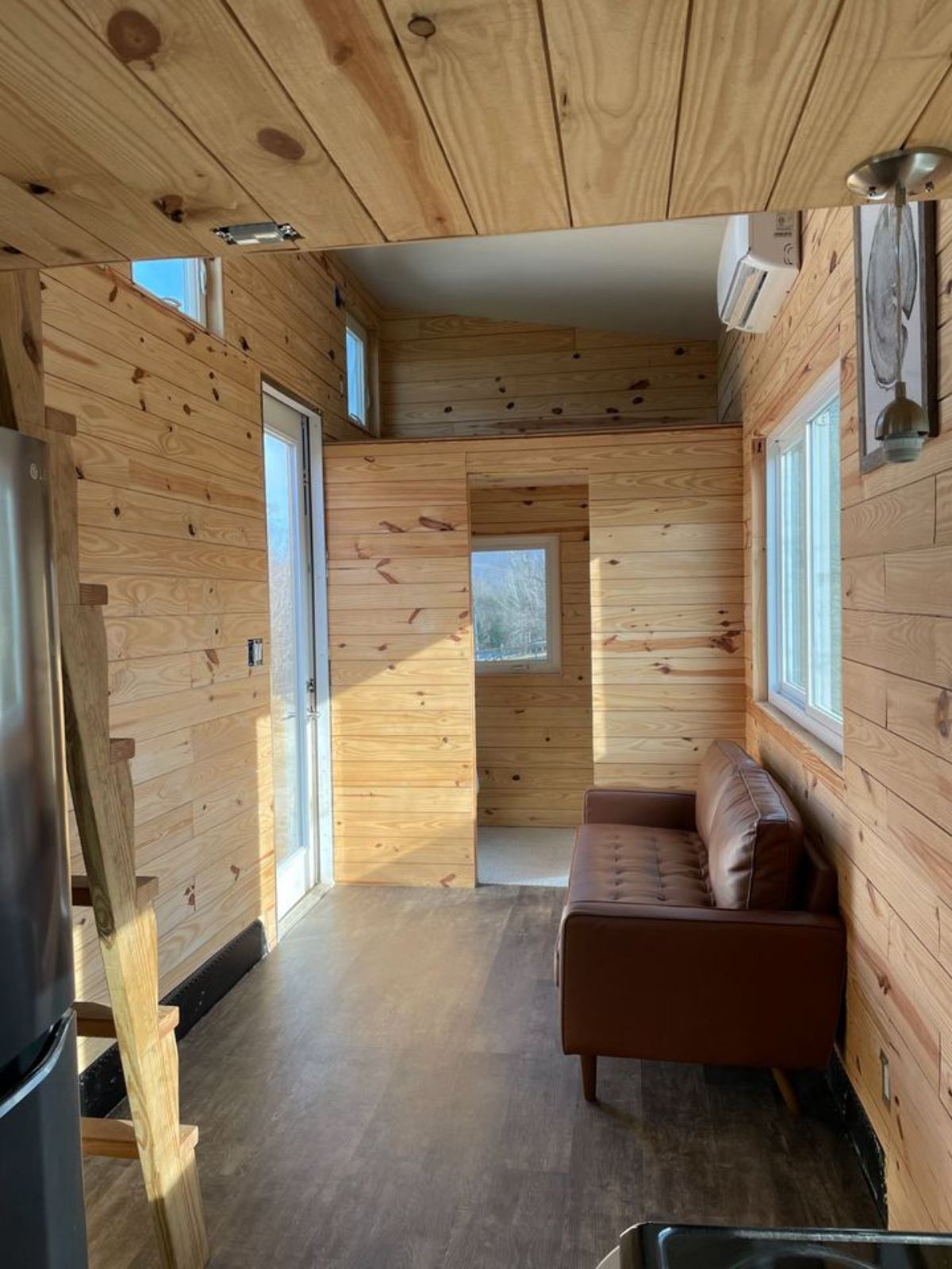 Wooden interior of 24’ Tiny House on Wheels plus a guest loft above the bathroom