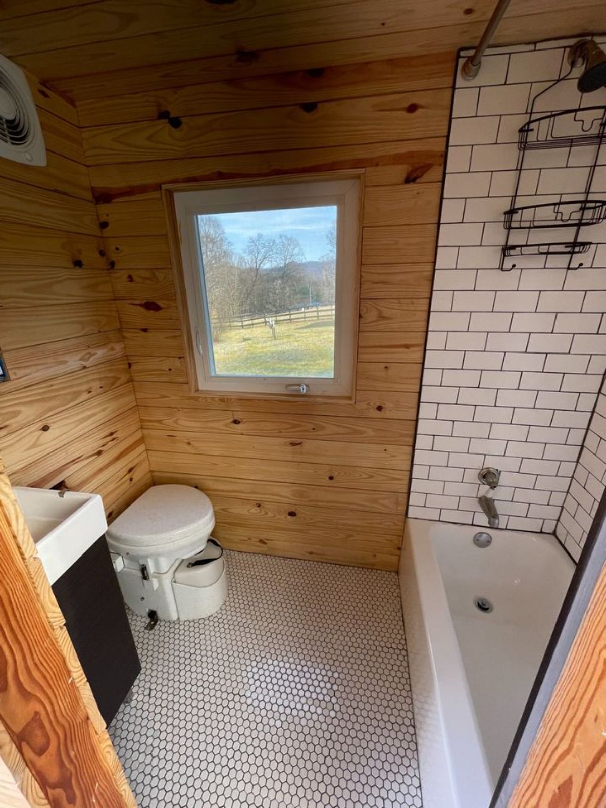 Bathroom of 24’ Tiny House on Wheels  has a wonderful interior with standard toilet, sink and a bathtub