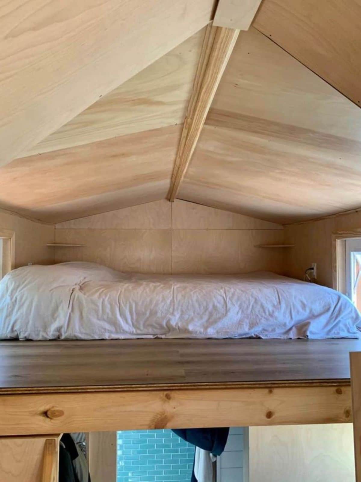 Queen mattress setup at loft of Cozy 23’ Tiny House on Wheels