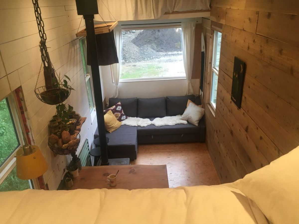 Living room has a huge window which makes the Cozy 24' Four Season Tiny House brighter
