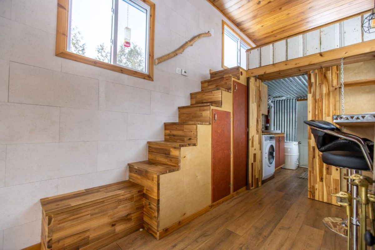 Storage under the stairs leading towards the bedroom of custom tiny home