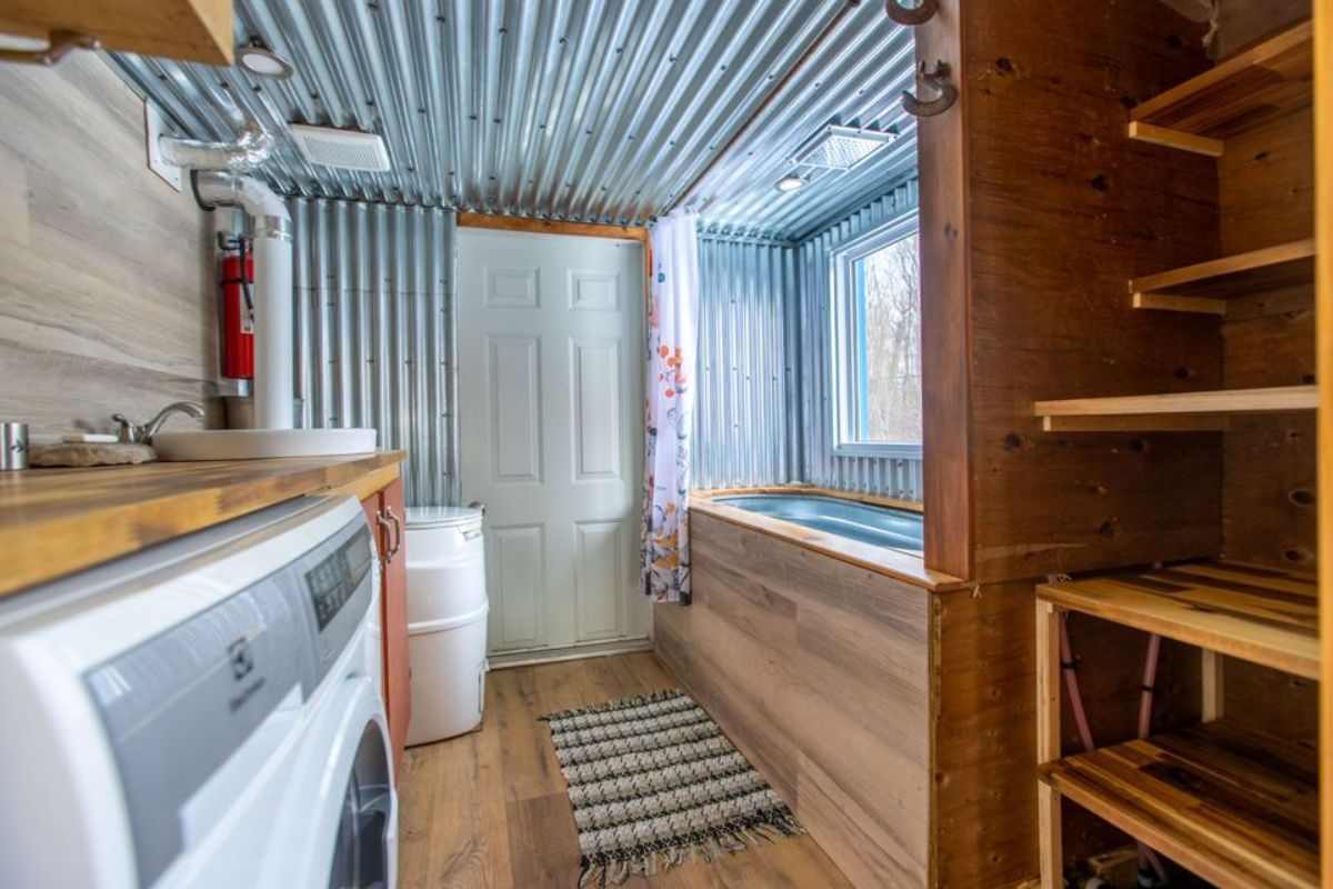 Clothing closet and vanity in bathroom of Custom Tiny Home on wheels