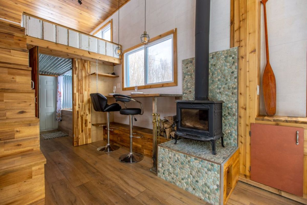 It has an electric fireplace in the living area of Custom Tiny Home on wheels