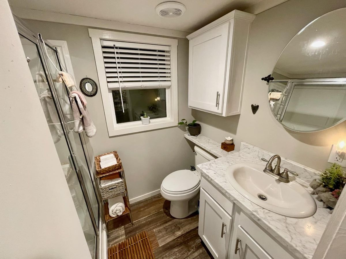 395 sf Tiny House has beautifully designed bathroom, toilet, sink with vanity, storage and mirror