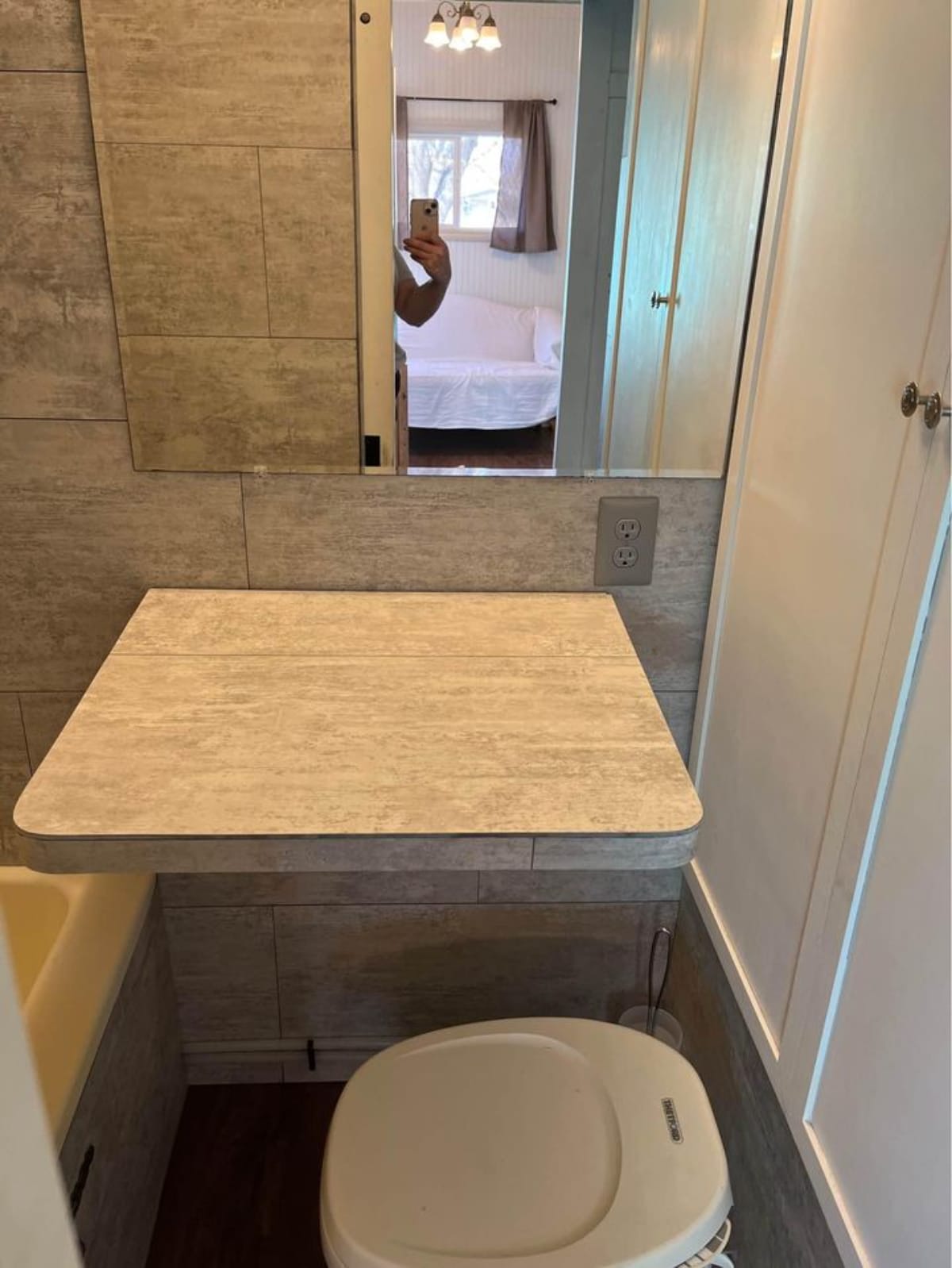 Bathroom has a huge mirror and foldable table