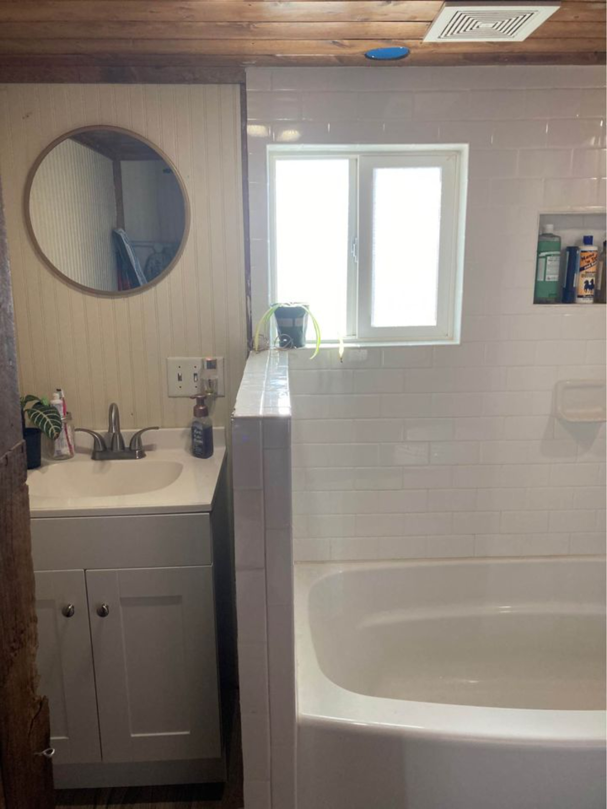 Bathroom of 30' Budget-Friendly Tiny House has a mirror & a sink with vanity