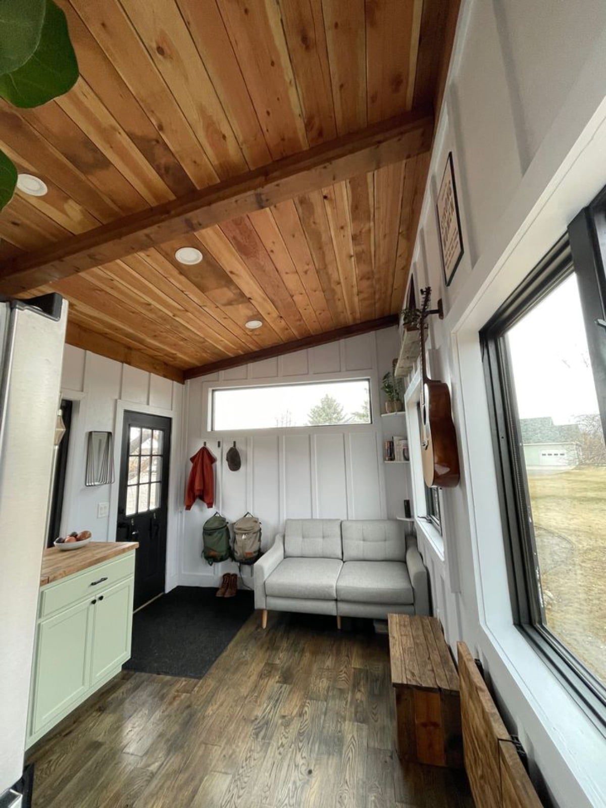 Living area of 30’ Tiny House on Wheels has a couch, storage and ample space to fit a small coffee table too