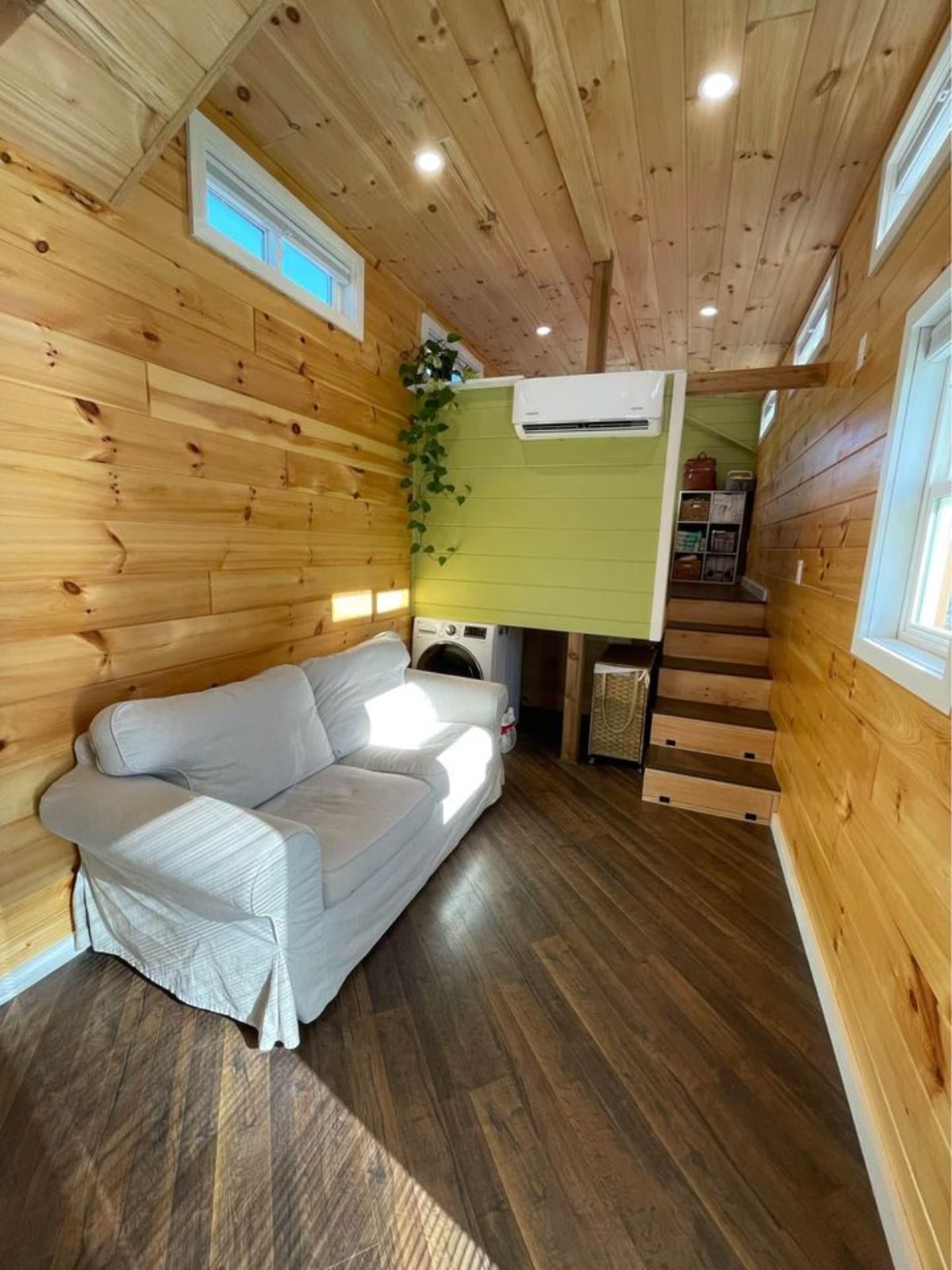 Living area of 40' Tiny House has a couch, washer dryer and air condition unit