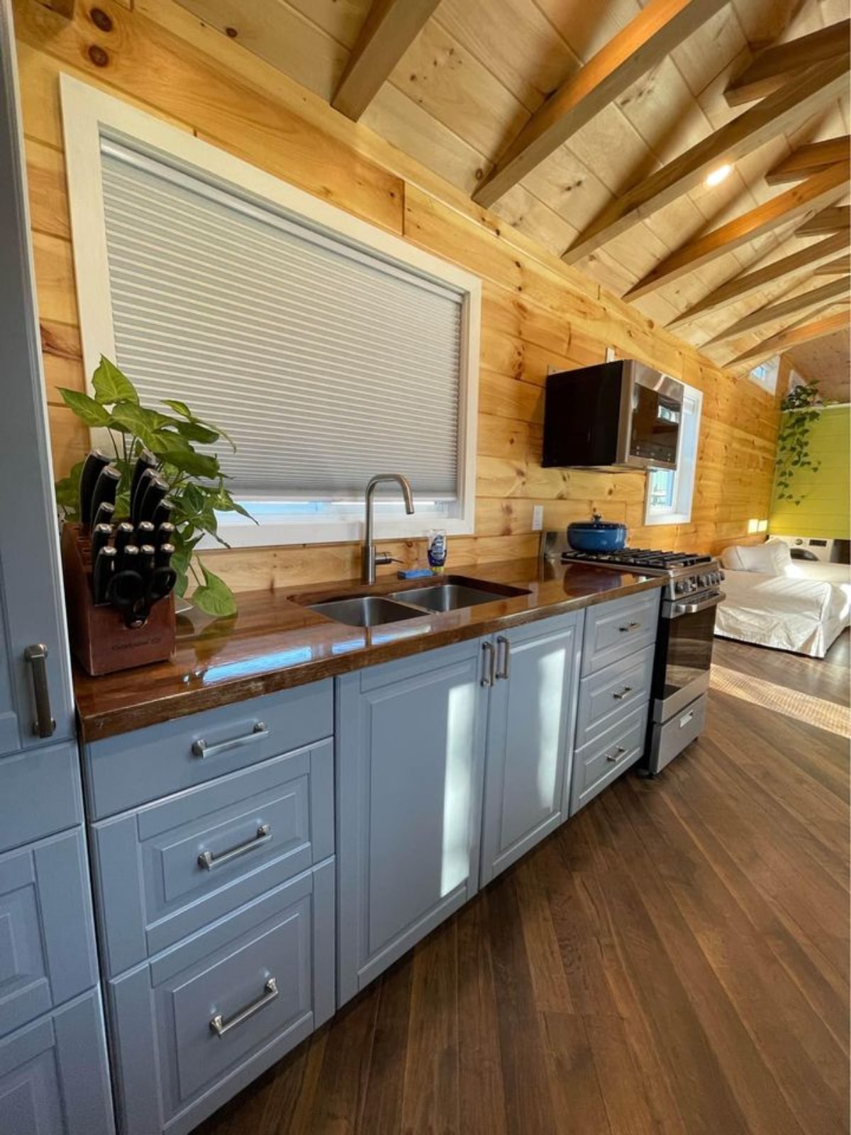 Well equipped kitchen area of 40' Tiny House has gas stove, microwave, double sink and pantry.