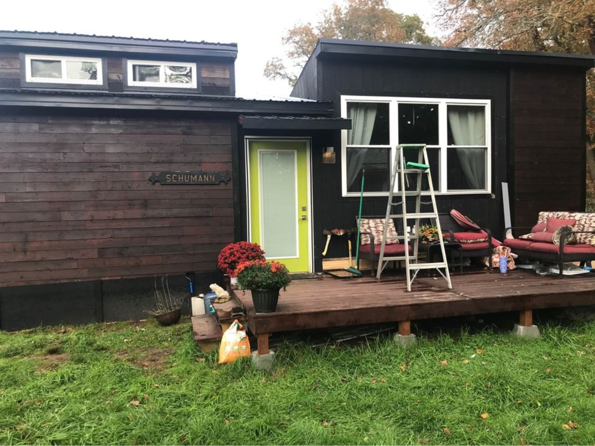 400 sf Tiny House on Trailer has a small desk outside the main door.