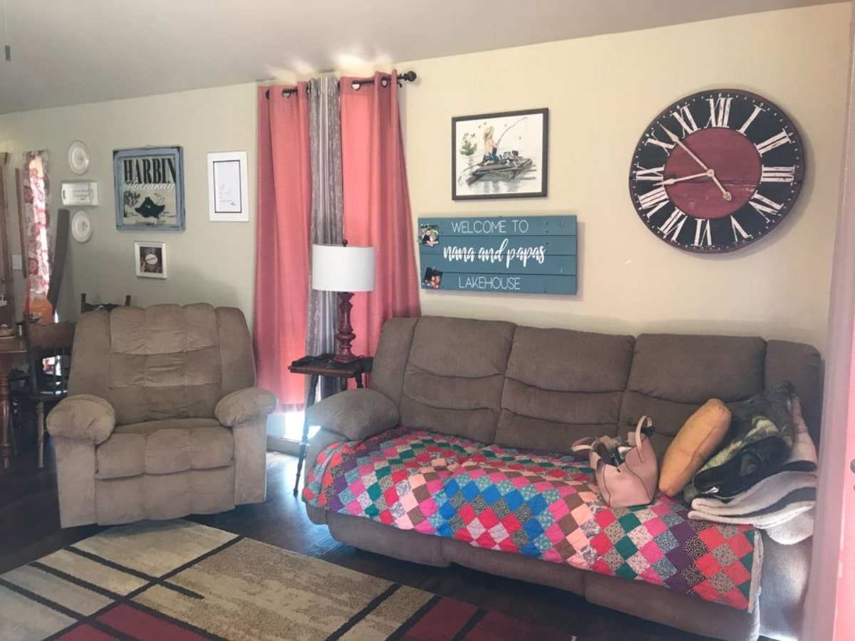 Living room of 46' Rustic Tiny House has a couch, recliner and television set with lots of storage