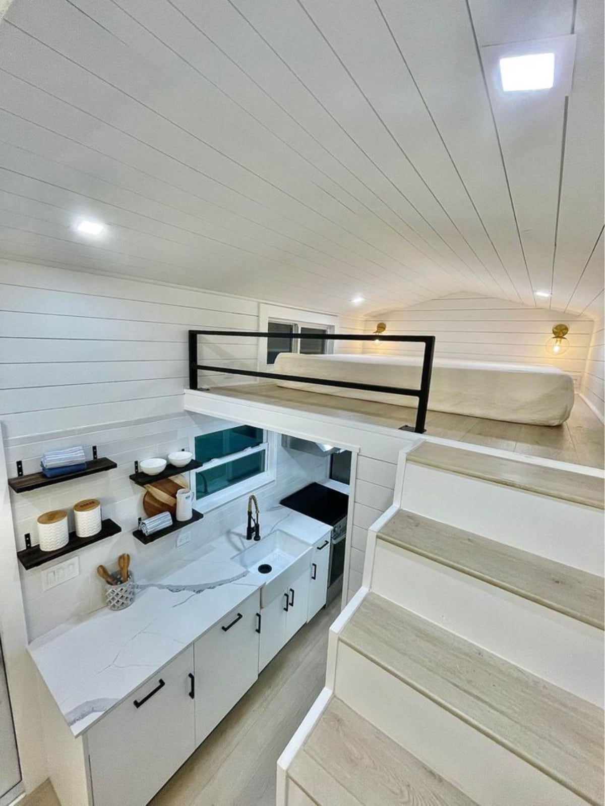 Storage space and kitchen area below the stairs and loft bedroom of New 24' Luxury Tiny Home