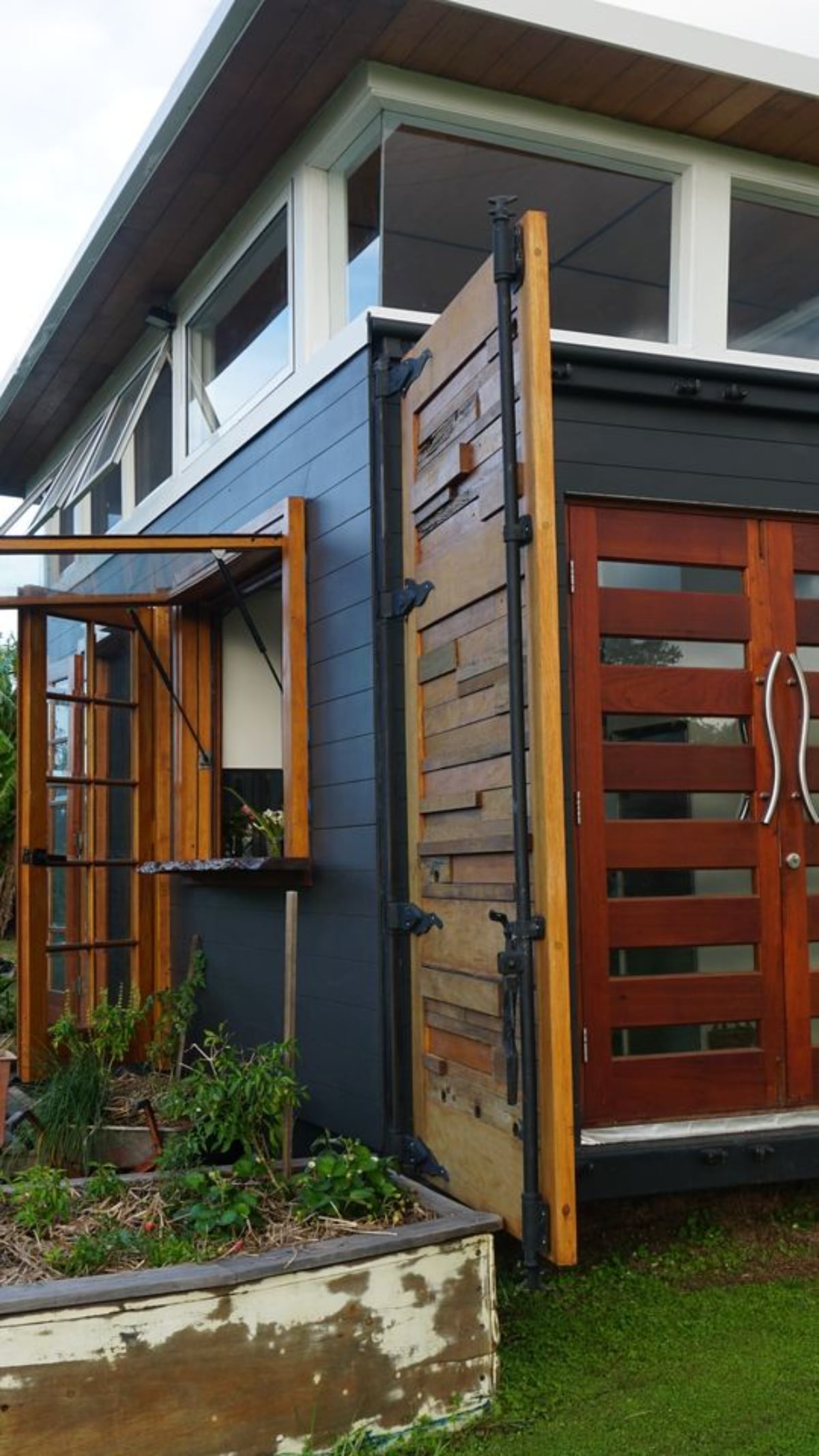 Wooden exterior and Side door view of Unique Tiny Home from container