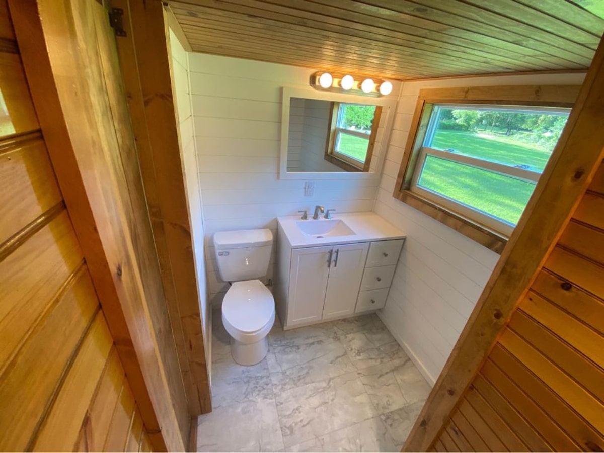 Standard toilet, Sink with vanity and mirror of 24' Tiny House with Porch