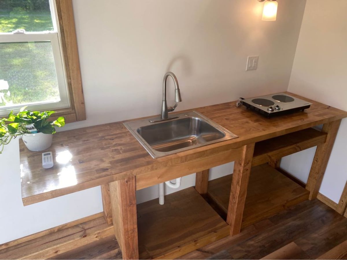 Kitchen area of 24' Tiny House with Porch has a countertop, sink and open space