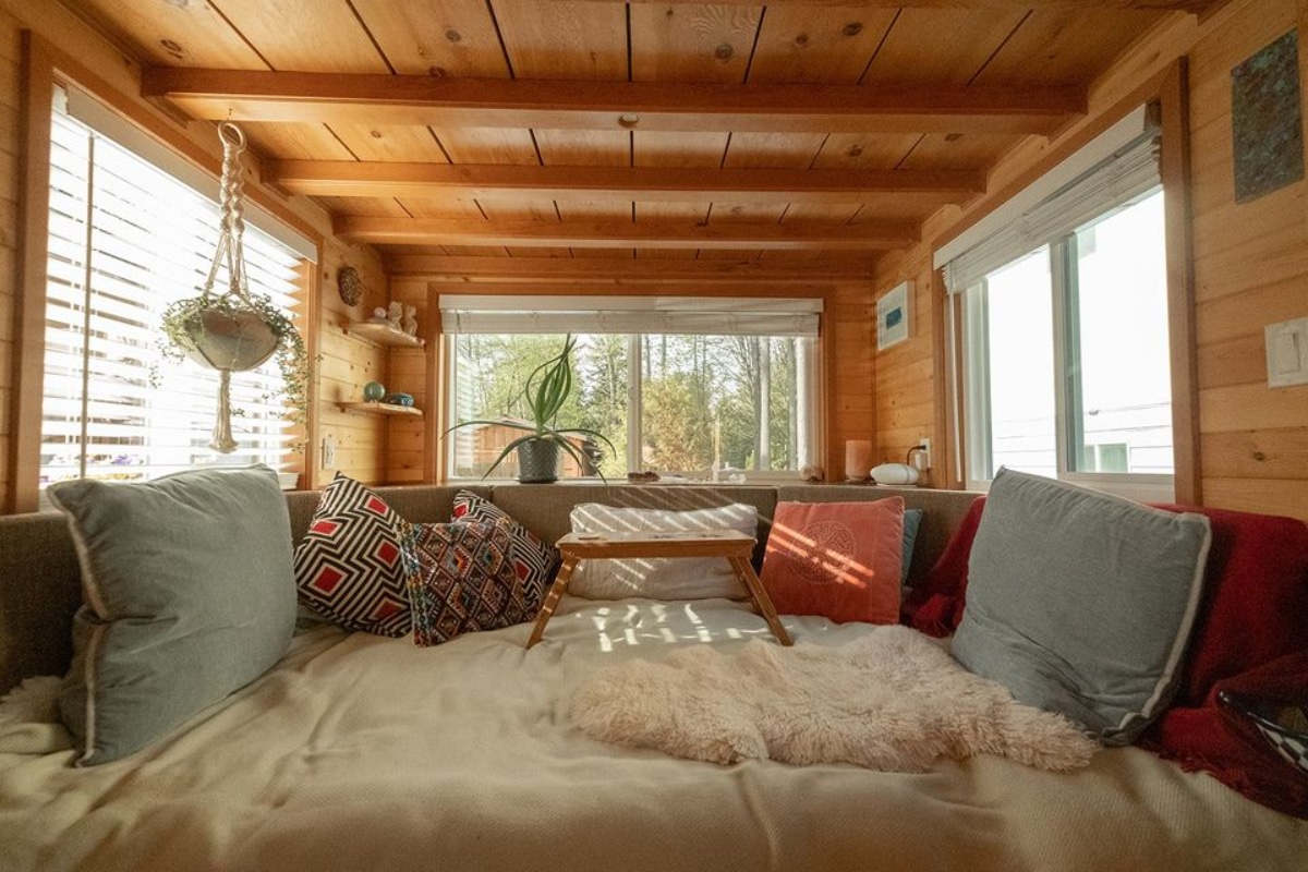 Living area of 30' Tiny House has a comfortable couch and huge windows