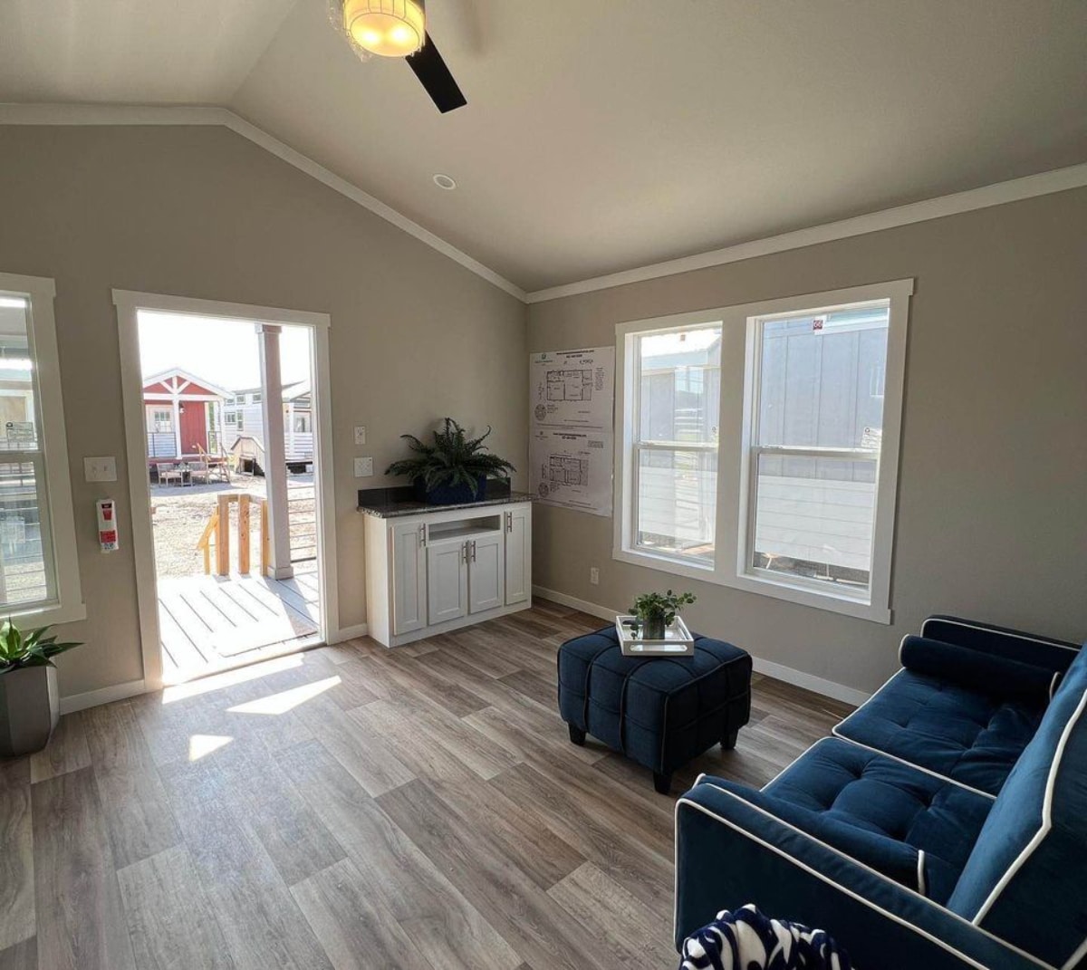 Spacious living area of 32' Ranch Style Tiny Home has a couch, coffee table and wall unit