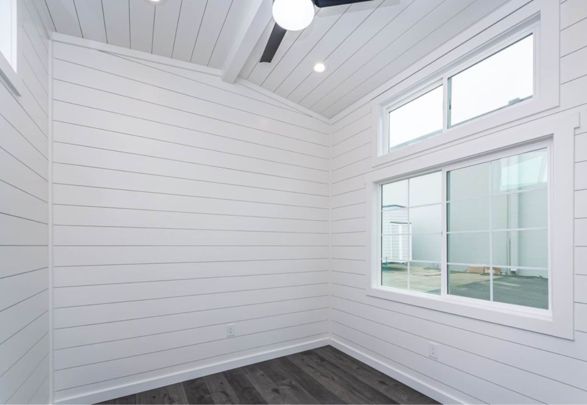 White walls main floor bedroom has ample space plus huge windows which makes it more brighter