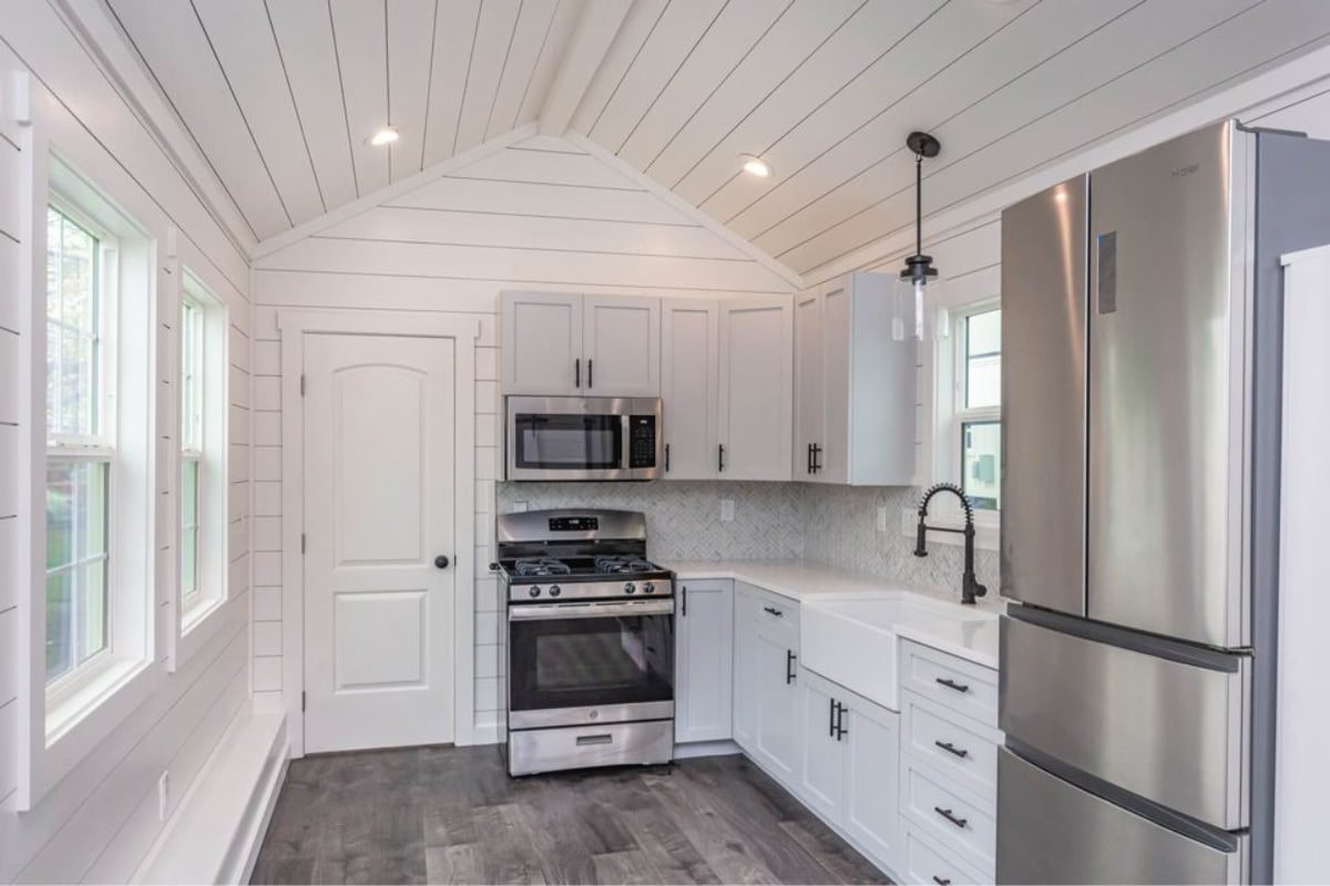 Well organised kitchen of Stunning 400 sf Tiny Home has counter top, sink, microwave and a huge refrigerator and lots of storage