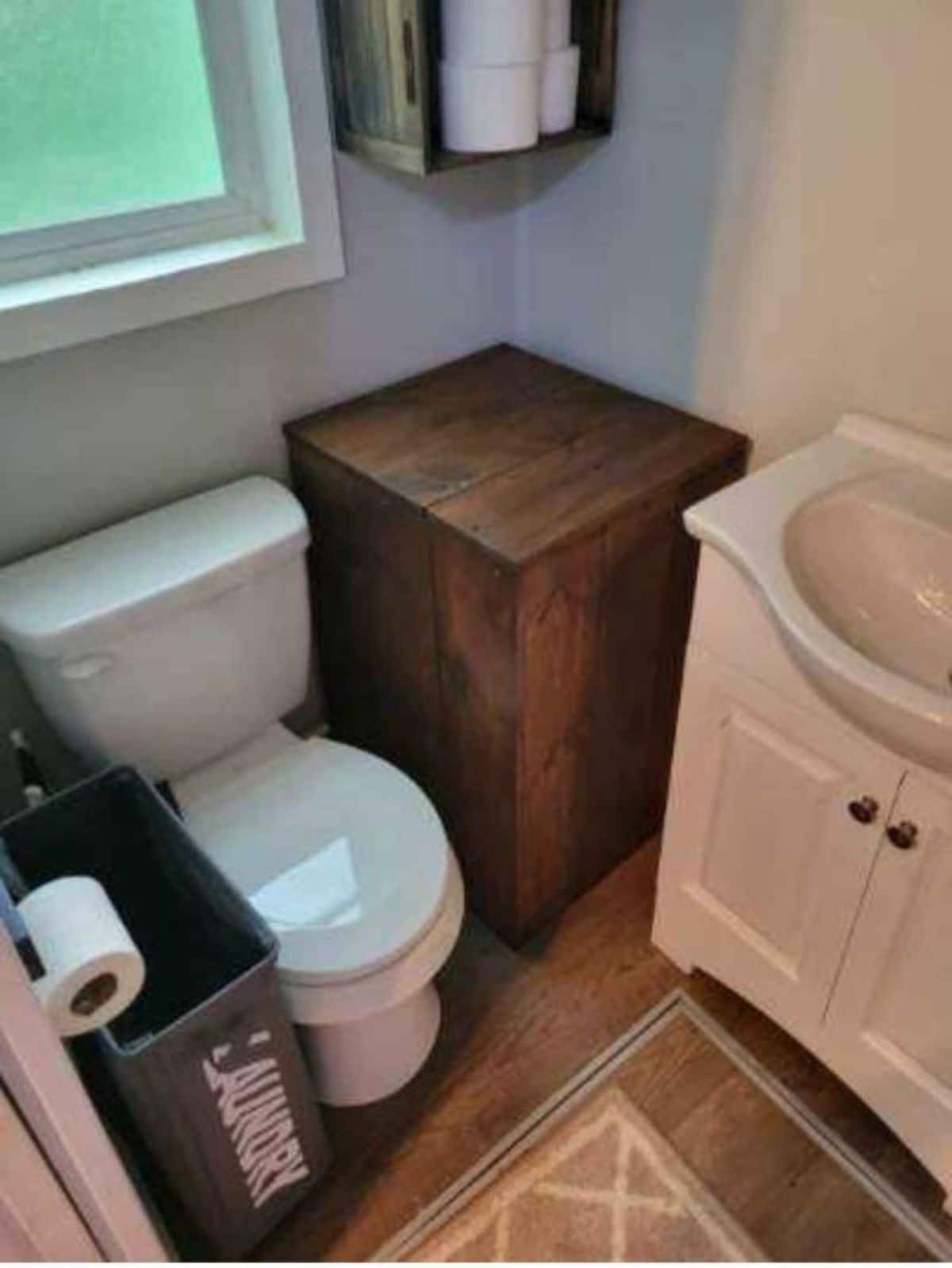 Standard toilet and sink with vanity plus storage in bathroom