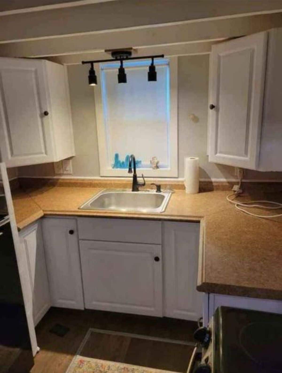 Kitchen area of 20’ Tiny House has a sink in the middle
