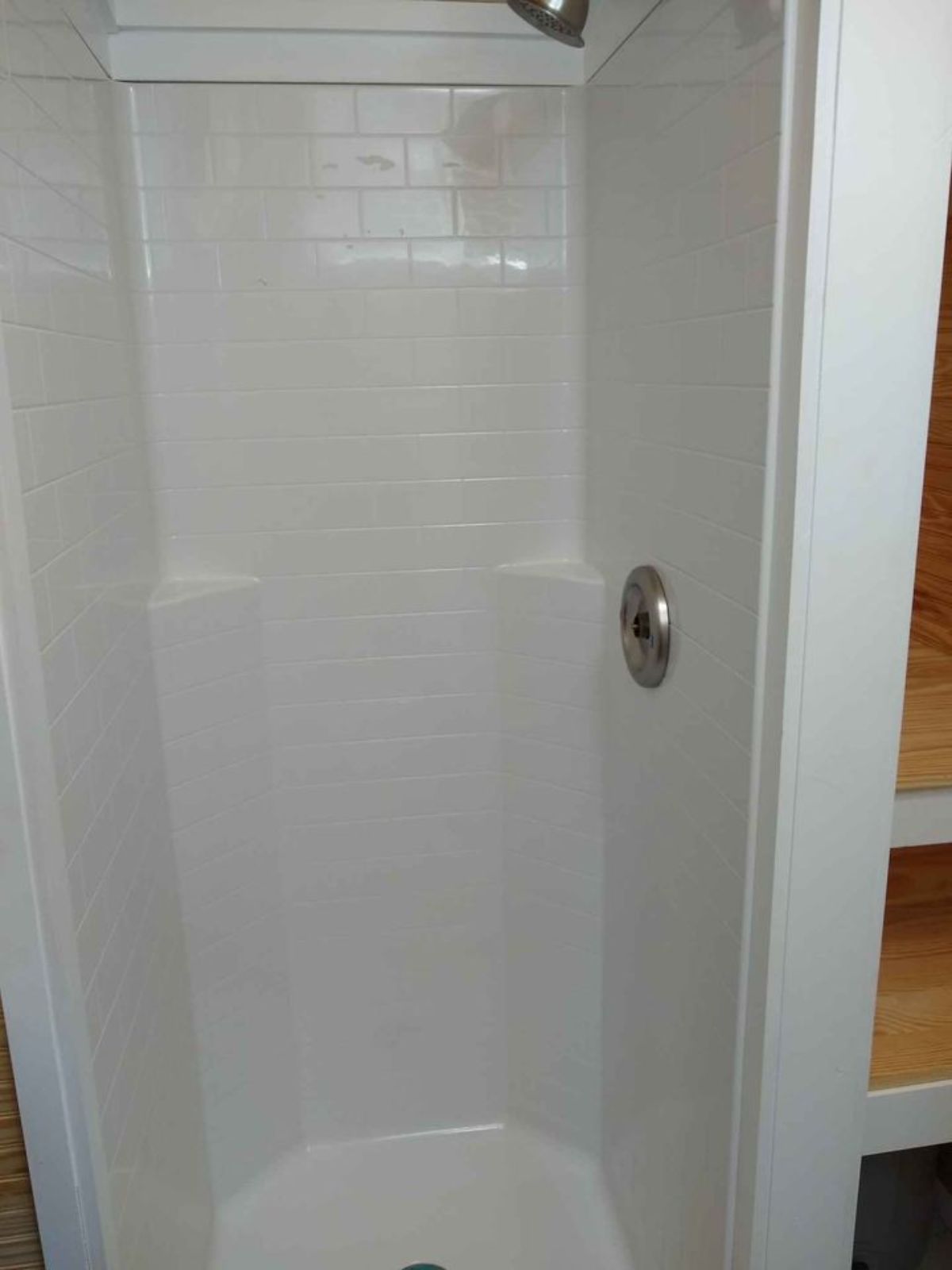Separate fiberglass shower stall installed in bathroom area of 24’ One Bedroom Tiny House