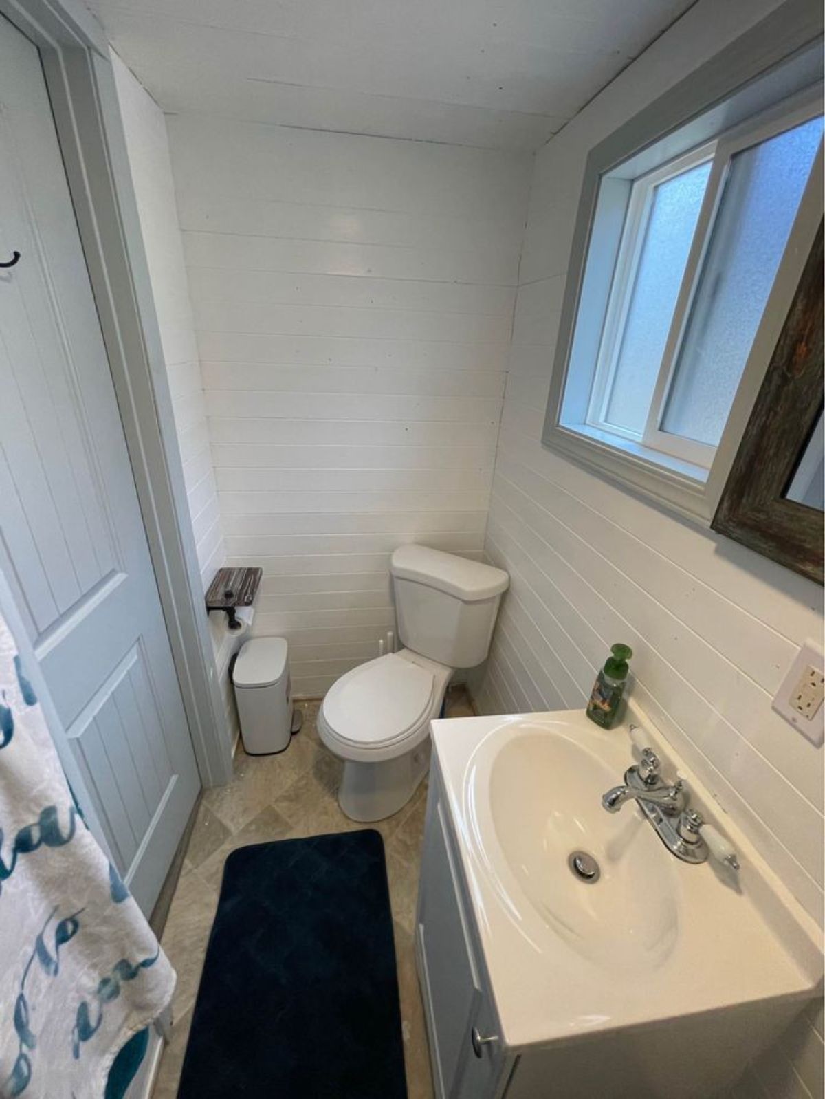 Bathroom of 24’ Turnkey Ready Tiny House has a toilet and sink with vanity
