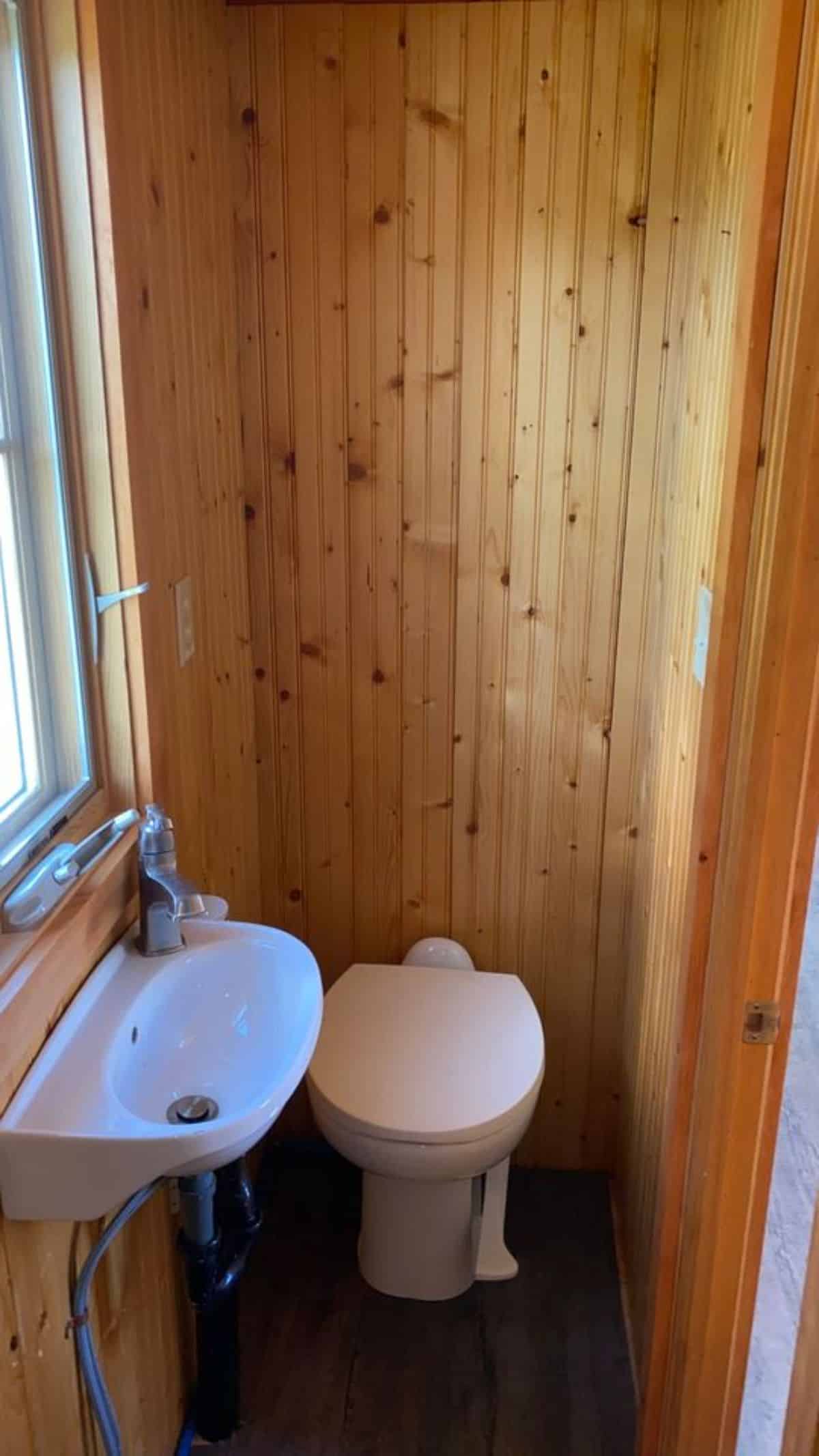 Standard toilet and sink in bathroom of 20’ Cozy Tiny House