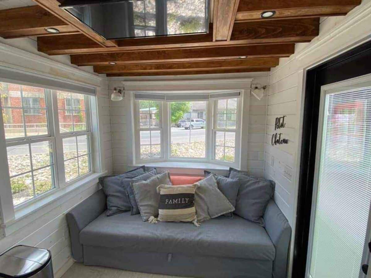Stunning living area of 24’ Tiny House has a couch with huge windows