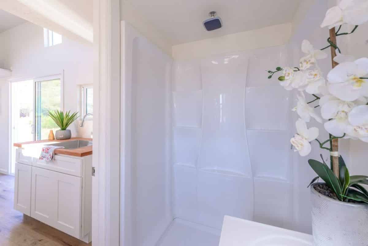 Separate glass door shower area in bathroom of 24’ Two Bedroom Tiny House