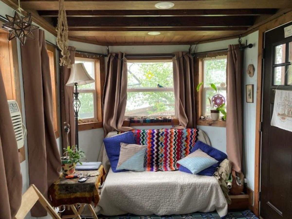 Living area of Charming Tiny House has a small couch and side tables