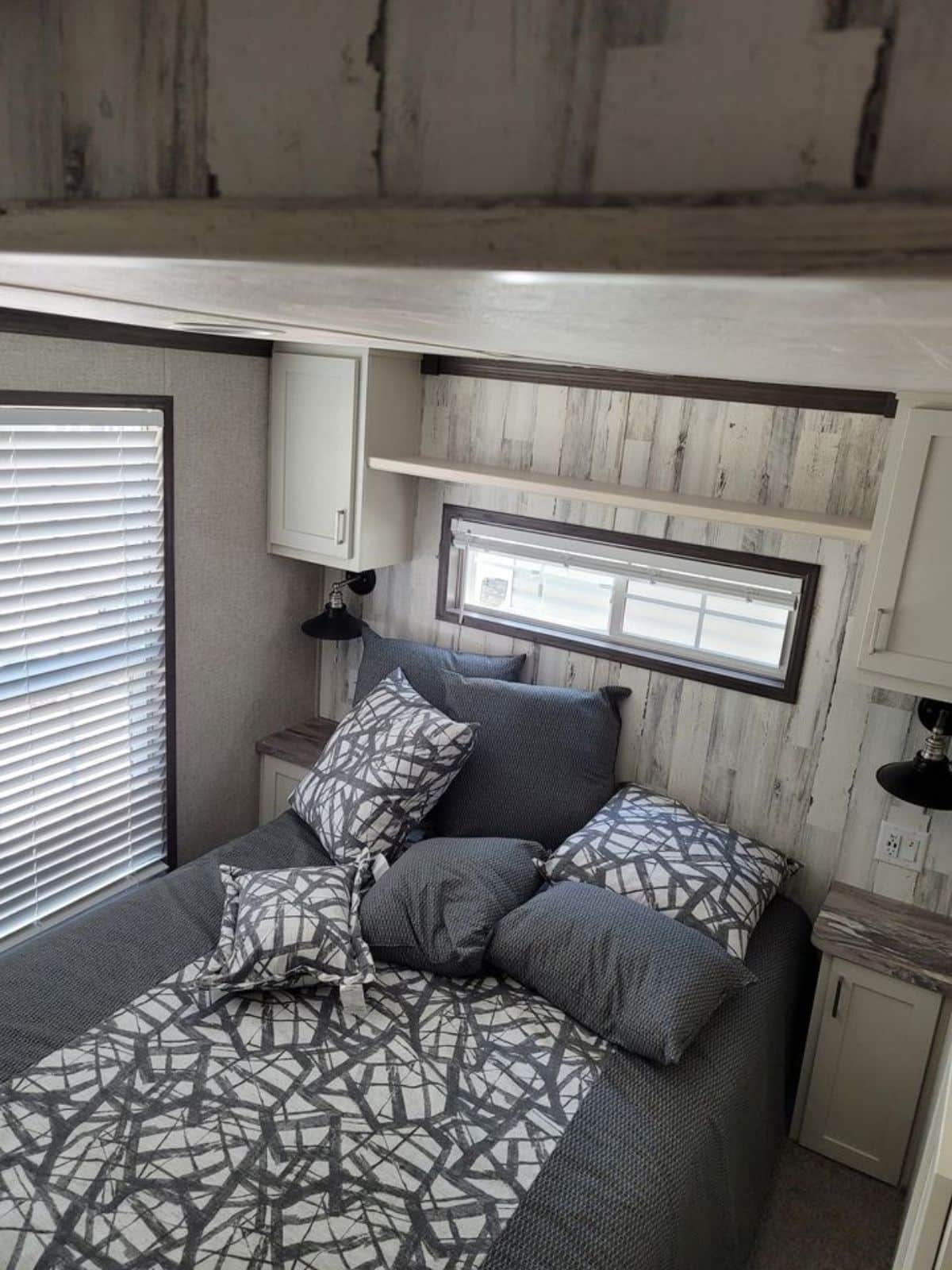 Bedroom of 2022 Park Model Tiny Home is comfortable with queen bed, side tables and still ample space