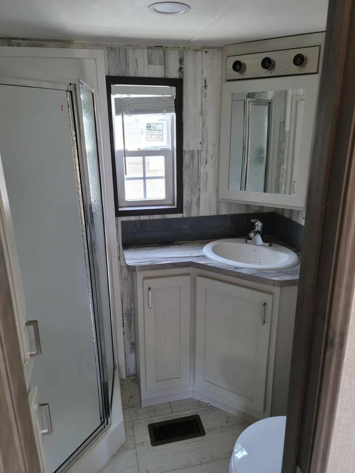 Bathroom of 2022 Park Model Tiny Home packed with sink with vanity and mirror