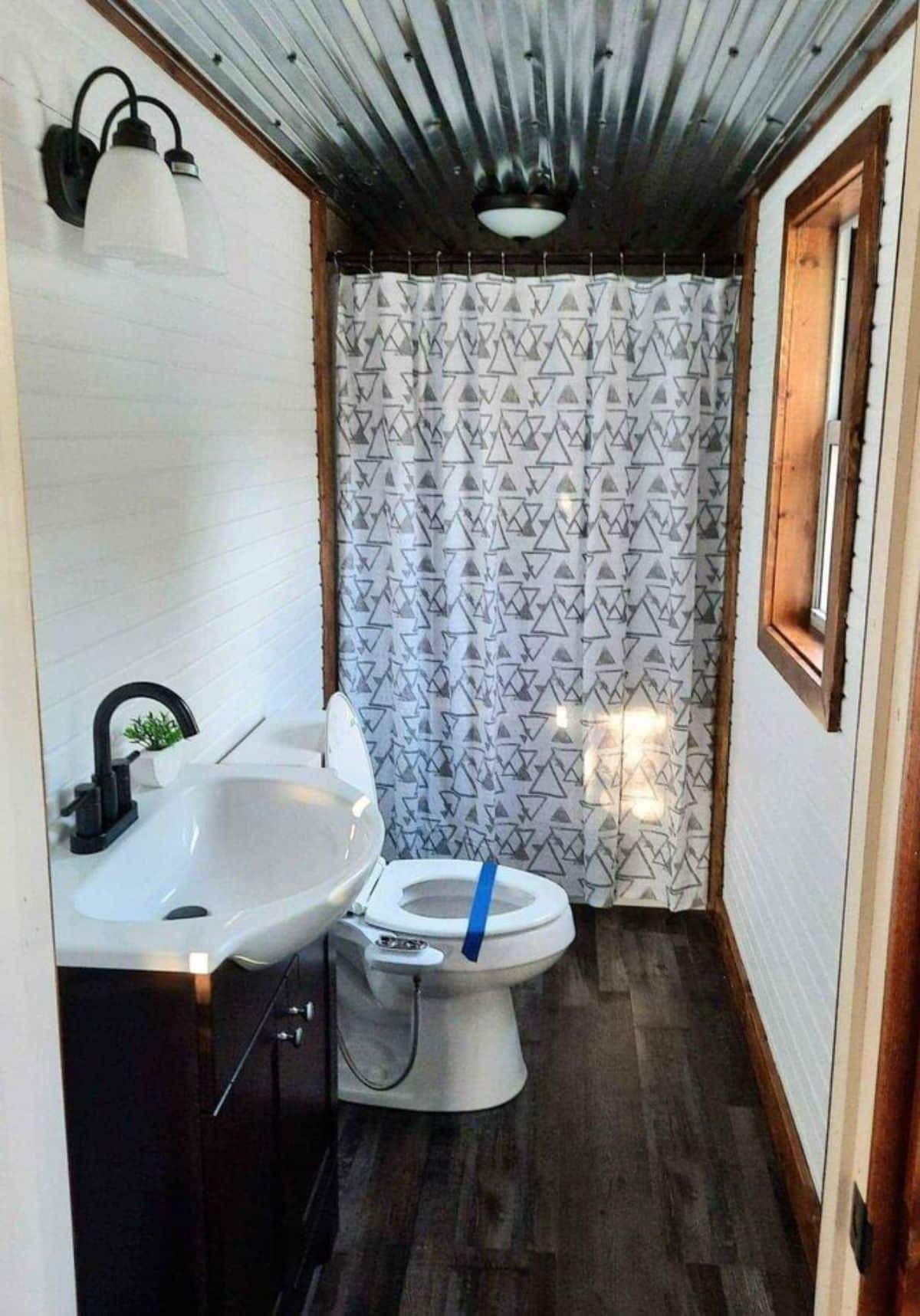 Sink with vanity and standard toilet in bathroom of 24’ Tiny Cabin