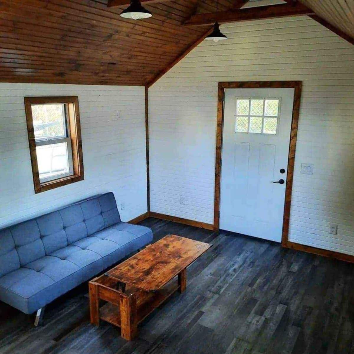 Living area of 24’ Tiny Cabin has a couch and center table