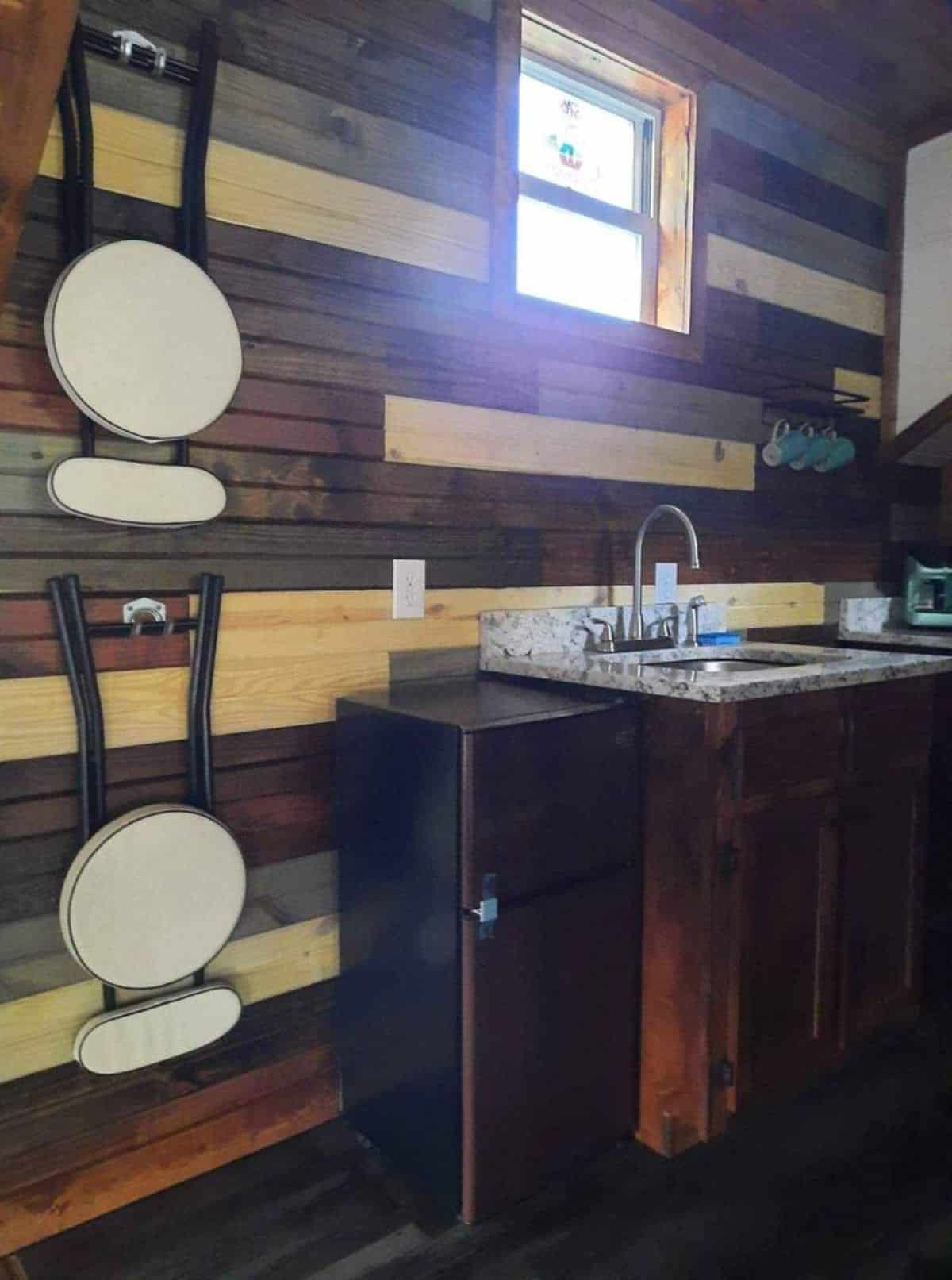 Kitchen area of 24’ Tiny Cabin has a refrigerator, sink with storage