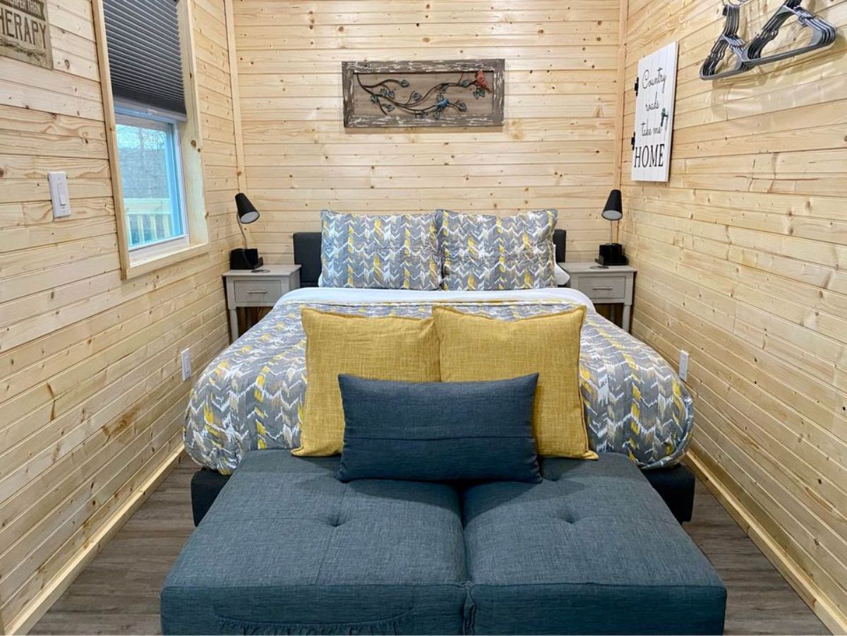 living cum sleeping area of 24’ Tiny Home Shell on Wheels has a bed with 2 side tables and couch