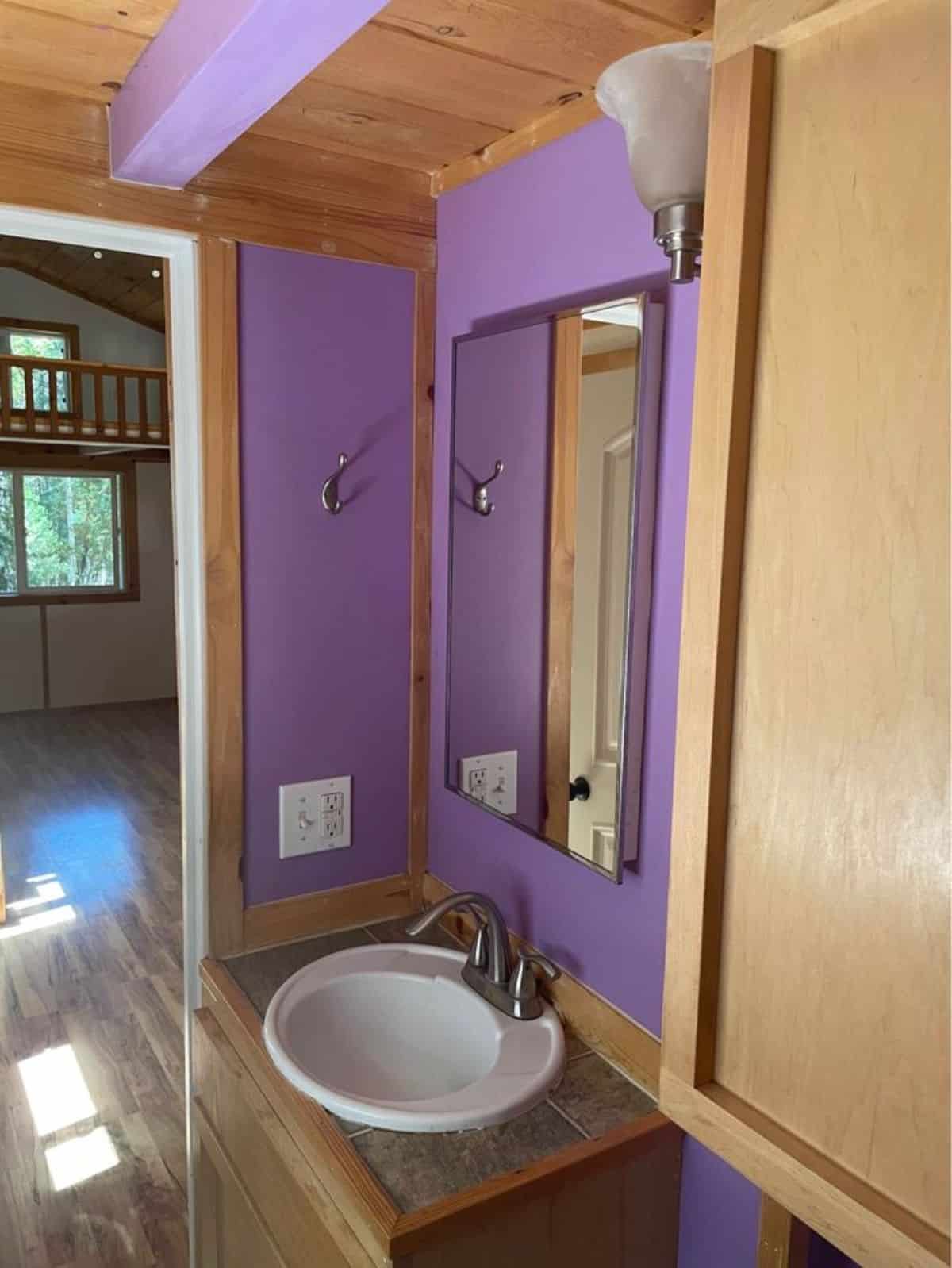 Sink with vanity and mirror and standard toilet in bathroom of 27’ Tiny House With Two Lofts