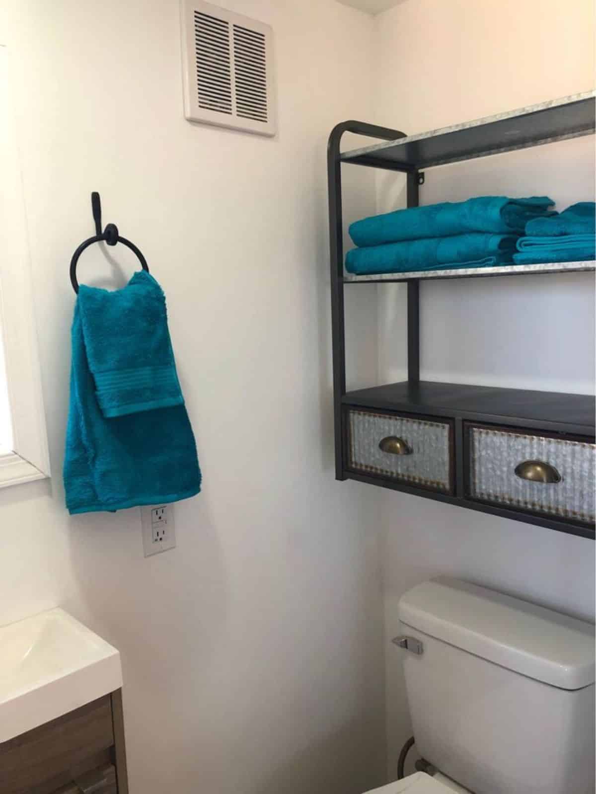 Sink with vanity & mirror, standard toilet and storage racks of 28’ Fully Furnished Tiny House