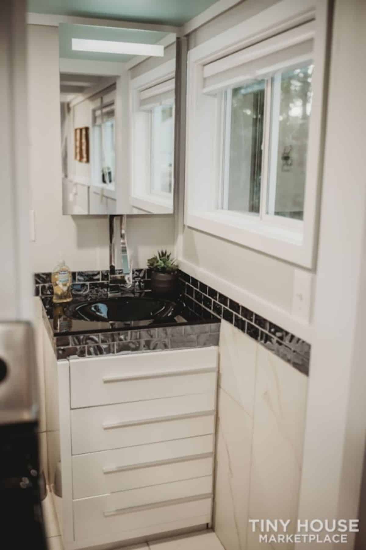 Sink with vanity and mirror in bathroom of 28' Tiny Home on Wheels