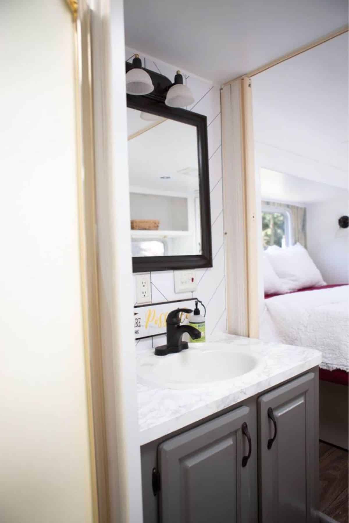 Sink with vanity and mirror in bathroom of 37’ Upgraded Tiny House